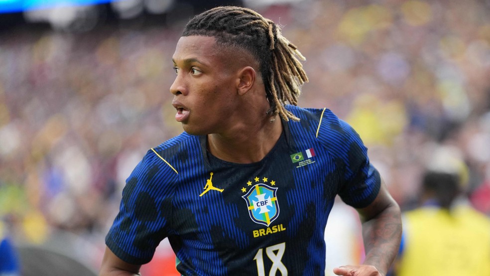 Douglas Santos, na partida entre Brasil e França, onde as duas seleções estrearam os novos uniformes; erro na costura é perceptível no ombro esquerdo — Foto: AFP