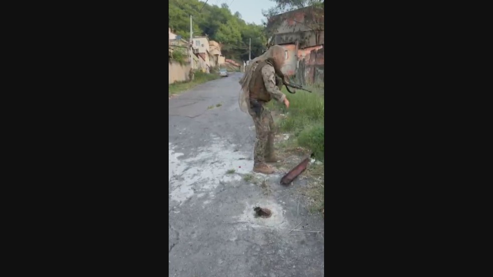 Agente do Bope retira barricada no Morro do Urubu, em Pilares — Foto: Reprodução/TV Globo